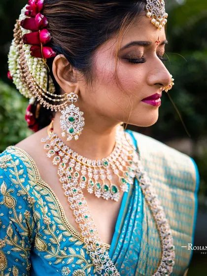 A side profile of Amileen, showcasing her intricate floral bun and the detailed embroidery on her blouse.