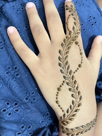 A delicate leafy vine in an infinity loop pattern on a child's hand.