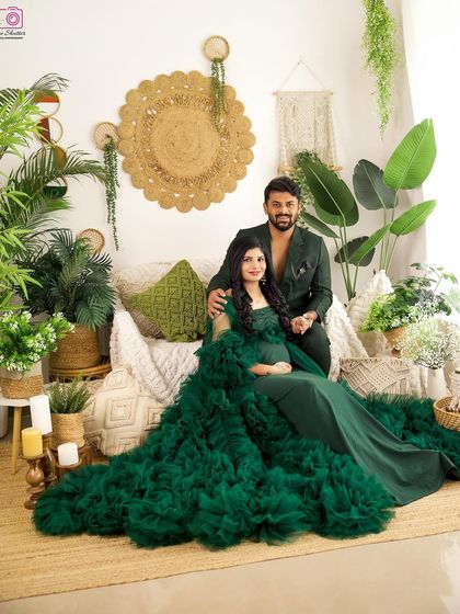 A grand and beautiful portrait of the couple seated in the lush, green-themed boho set. It’s a celebration of life and love.