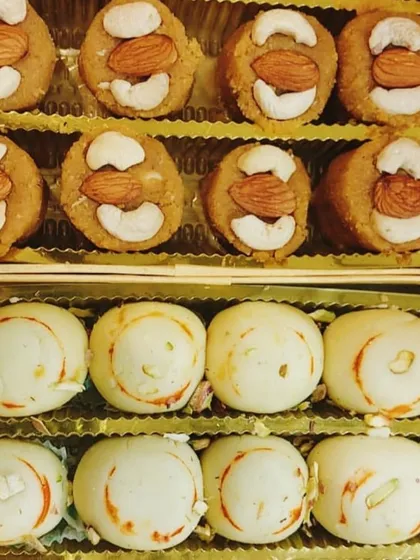 A festive box containing our special Peda varieties. The top row features Atta Badam Pedas, while the bottom row has classic Kesar Malai Pedas, both garnished beautifully for a Karva Chauth celebration.
