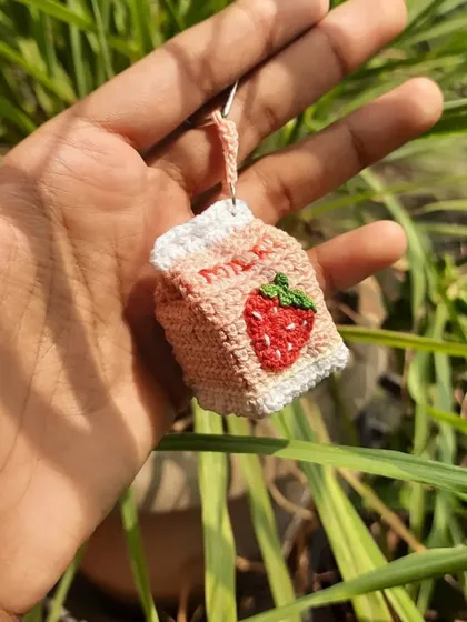 A custom strawberry milk carton charm. The tiny embroidered seeds and leaves are some of my favorite details to add.