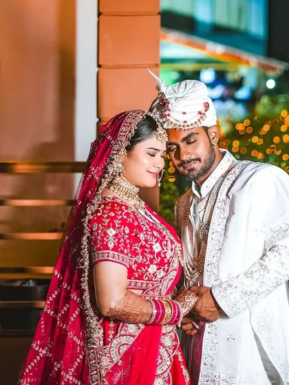We believe the most beautiful moments are often the unposed ones. Here, the couple shares a quiet, tender moment together, framed by the warm glow of fairy lights. This is the natural, romantic style that defines our wedding photography.