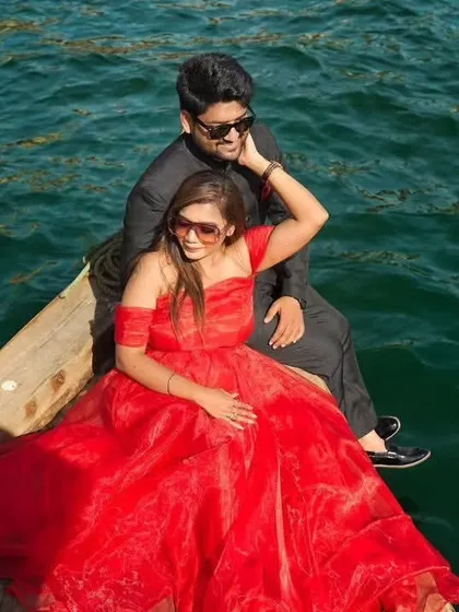 A romantic boat ride in Dubai. The bride's vibrant red dress creates a stunning pop of color against the deep blue water, making for a beautiful and relaxed portrait.