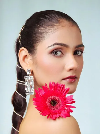 A creative beauty portrait using a flower as a prop. This adds an artistic and colorful element to a standard headshot.