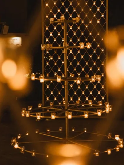 A multi-tiered candle stand, creating a warm and magical glow for an evening event.