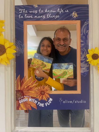A father and daughter proudly present their Van Gogh-inspired wheat field paintings. A wonderful bonding activity for the whole family.