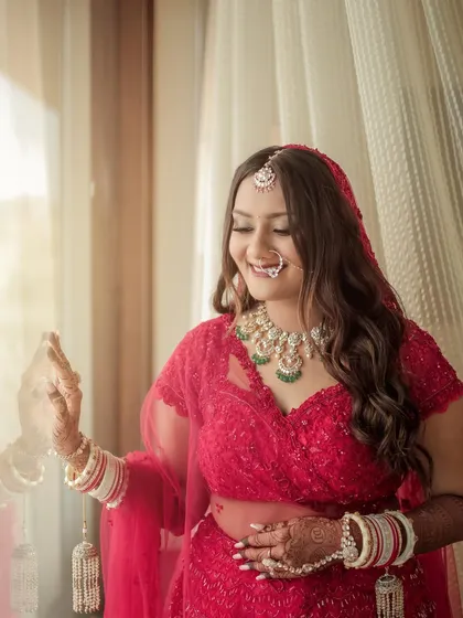 The bride enjoying a quiet moment by the window. The natural light highlights the dewy finish of her makeup and the soft shimmer on her eyes, a key part of my signature bridal style.