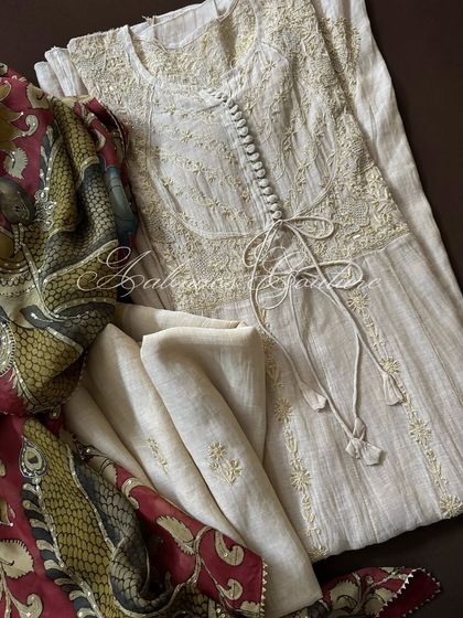 A three-quarter view of the laid-out ensemble, showing the relationship between the Anarkali, its coordinated lower, and the artistic Kalamkari dupatta.