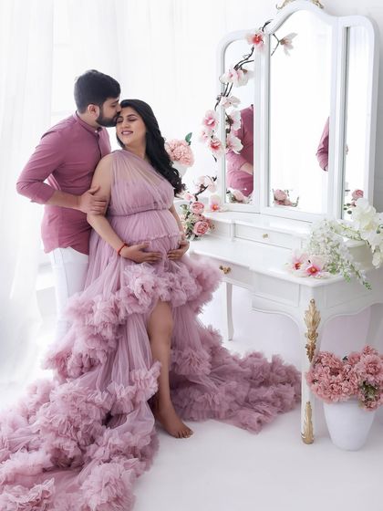 A dreamy, floral-themed maternity session. The soft pink ruffled gown and vanity setup create a whimsical and feminine atmosphere, perfect for a fairytale-inspired shoot.