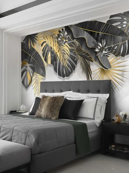 This bedroom features a dramatic wallpaper with black, grey, and gold tropical leaves, creating a chic and modern accent wall.