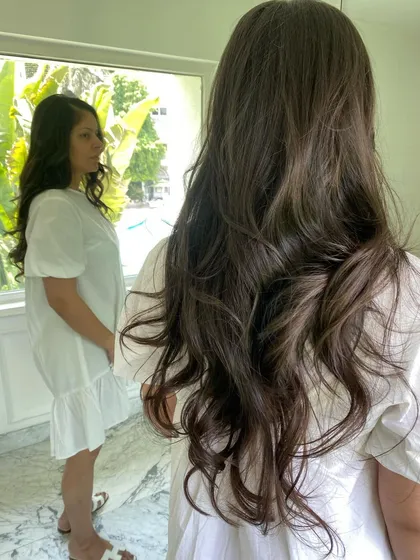The reflection in the mirror shows the beautiful shape and movement of this long, layered summer cut.