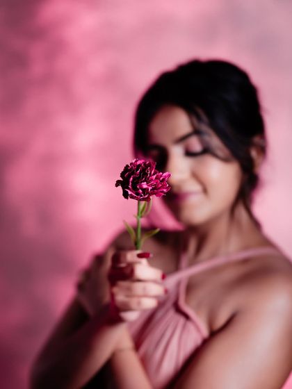A creative, dreamy shot of Namratha from our glam photoshoot, set against a pink, smoky background.