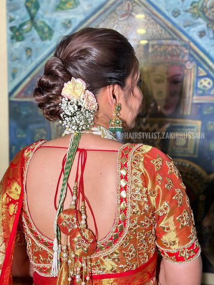A full view of the traditional floral bun, showing how it complements the bride's saree and jewelry.