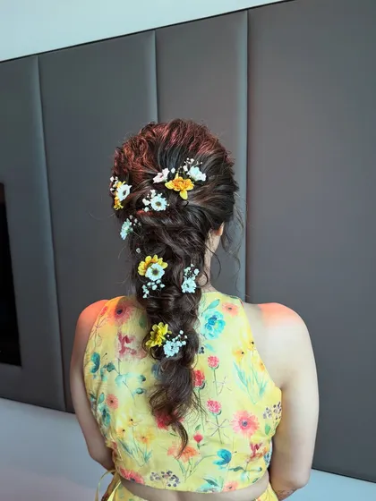 A final look at the stunning floral messy braid. This hairstyle is perfect for a Haldi or Mehendi ceremony, adding a touch of natural beauty.