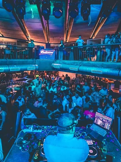 A view from my console at a packed, multi-level club. My goal is simple: to make every person in the venue, from the front row to the back, lose themselves on the dance floor.