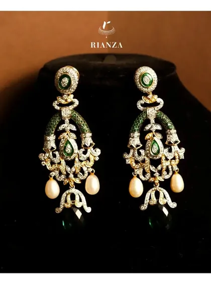 I design pieces that are both stunning and versatile. These elegant danglers, with their intricate diamond work, vibrant emeralds, and classic pearl drops, can be styled beautifully for a sangeet, cocktail party, or even after the wedding.