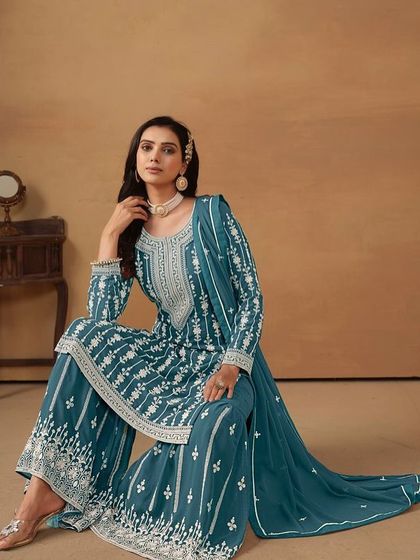 This teal salwar kameez is a classic. The white thread embroidery creates a stunning contrast, and the sharara pants add a modern, fashionable touch.