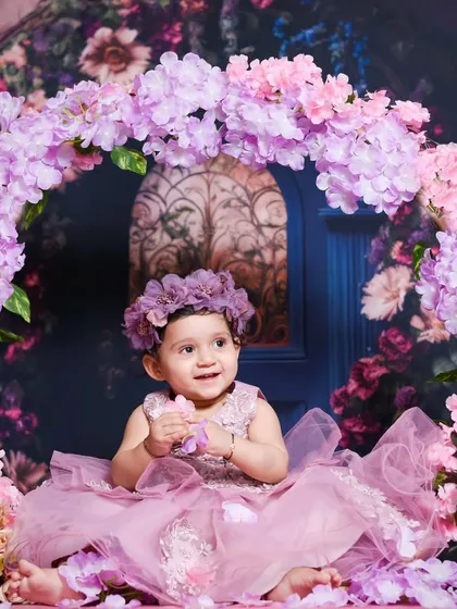 A beautiful portrait in a floral wonderland. The soft pink and purple tones of the flowers and her dress create such a gentle and classic look for a baby girl's photoshoot.