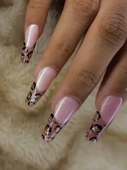 A close-up of a leopard print French manicure on long square nails.