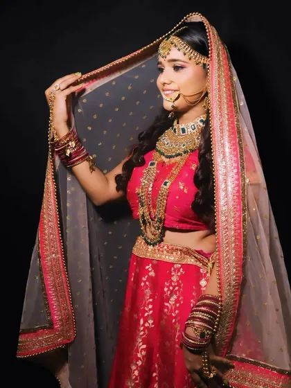A classic bridal pose with the dupatta veil. I ensure the makeup looks stunning from every angle, whether veiled or unveiled.