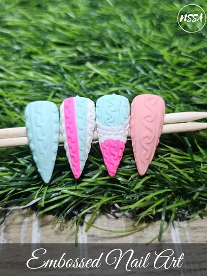Get cozy with this embossed "sweater nail" art. Using a special technique with our gels, we create a raised, textured pattern that looks and feels like a knitted sweater, shown here in soft pastel colors.