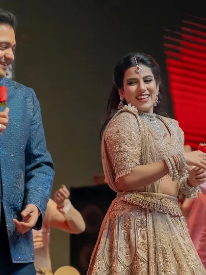 A candid moment of joy during a romantic duet. The groom holds a rose, adding a classic touch to this performance filled with genuine smiles and connection.
