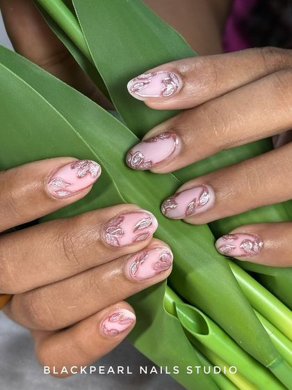 This set features a soft nude matte base with detailed rose gold floral accents and a silver cat-eye shimmer. It’s a perfect example of quiet luxury, combining subtle colors with intricate, sparkling details.