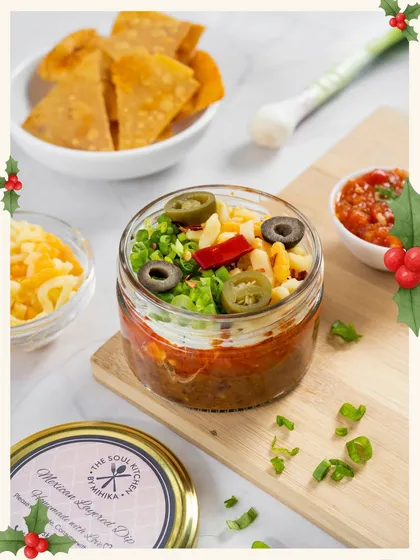 My Mexican layered dip in a jar, looking festive with its red and green toppings.