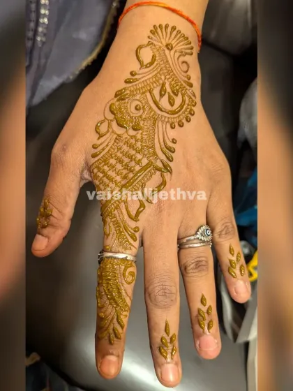 A simple Arabic design for a single finger and the side of the hand. This is a very minimalist and modern choice.