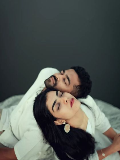 A peaceful and artistic portrait of a couple resting together. This minimalist shot focuses purely on their serene connection and comfort with one another.