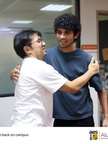 A teacher and a former student share a warm hug during an alumni reunion on campus. These moments capture the heart of our community.