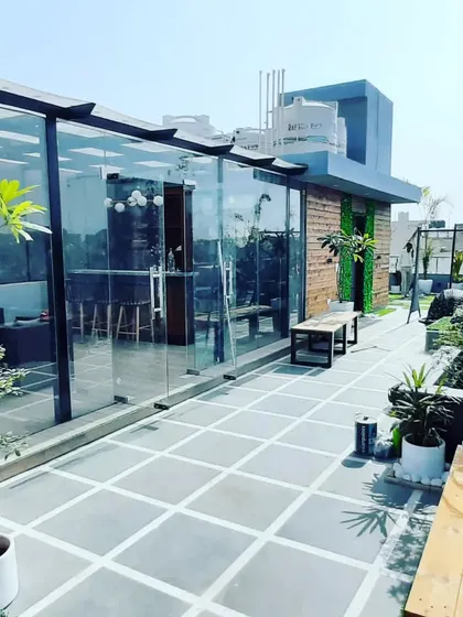 A complete glass room on a terrace, surrounded by landscaping. This creates a perfect indoor-outdoor feel, letting you enjoy the garden from a climate-controlled space.