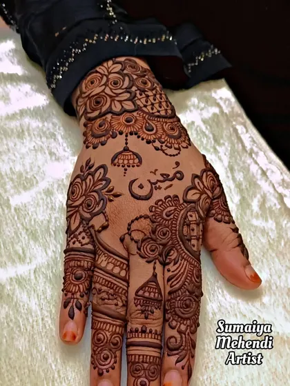 A simple henna design with personalized elements like a name and a small mosque motif.