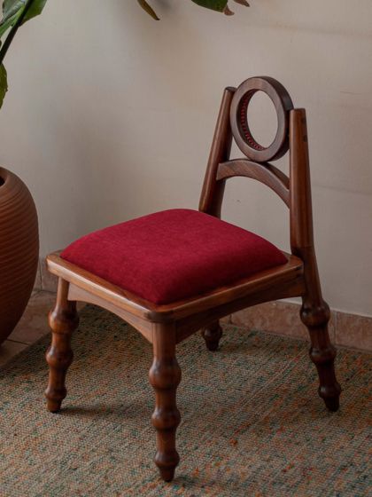 A series of images detailing the Manjadi chair, from its hand-turned legs inspired by the seed pod to the vibrant red upholstery. These shots highlight the craftsmanship and the deep cultural narrative behind this unique design.