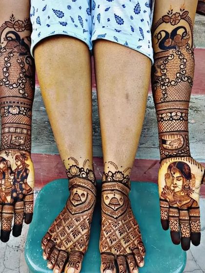 A complete bridal set with couple portraits on the hands and matching jhumka (earring) designs on the feet.