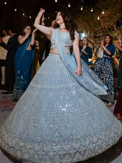 A beautiful shot of the bride twirling in her powder blue lehenga on the dance floor.