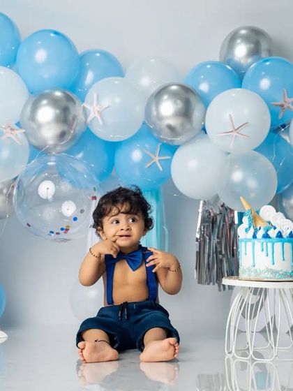A curious look before the cake comes out. The details in this ocean theme include little starfish on the balloons and seashells on the floor.