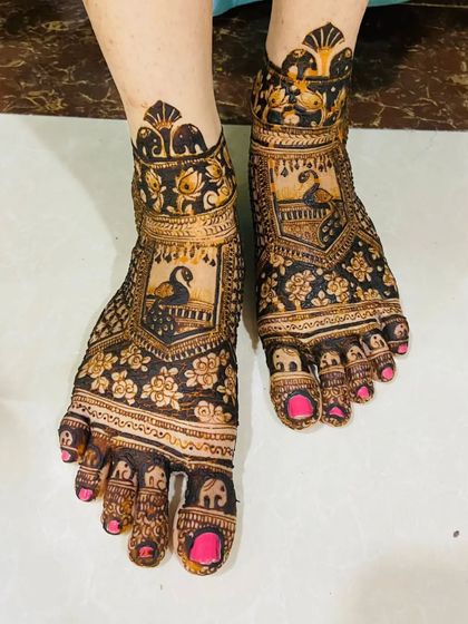 A full-coverage bridal feet design featuring peacocks, elephants, and floral patterns, ensuring the bride's feet look as decorated as her hands.