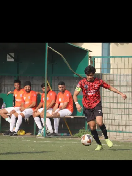 A player skillfully dribbling past an opponent while the rest of the team watches from the bench.