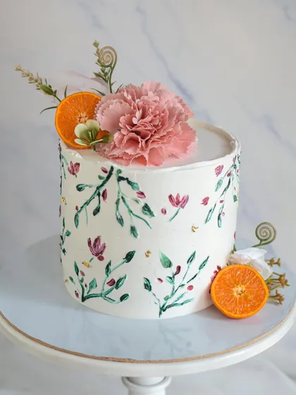 This hand-painted cake is like a garden in bloom. I used a palette knife to create delicate floral patterns and leaves, complemented by fresh carnations and orange slices for a fresh, artistic look.