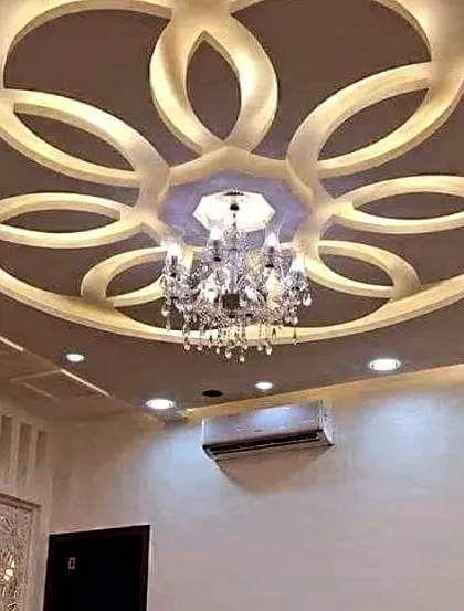 For those who love a grand statement, I create designs that perfectly frame a beautiful chandelier. This floral-inspired POP work adds a layer of pure elegance to this living room.