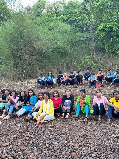 A group of campers rests on a hillside during a trek at the Dandeli summer camp.
