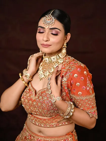 A beautiful shot capturing the essence of a modern bride. The pink eyeshadow and muted lips are a perfect match for the vibrant orange outfit.