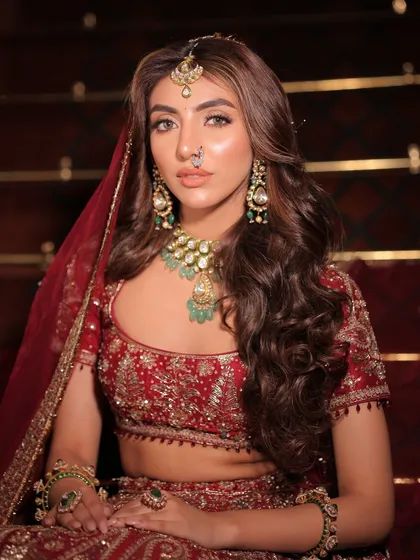 Another portrait that exudes royalty. The combination of the deep red outfit and the elaborate green jewellery creates a classic and unforgettable bridal aesthetic.
