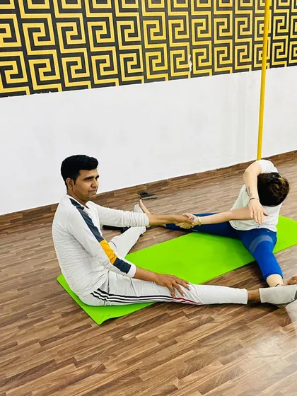 Here, I am providing an assist in a seated wide-legged stretch. This kind of hands-on help ensures you get the correct alignment for a deeper, more effective stretch.