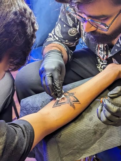 The tattooing process in action. You can see me carefully wiping the area to ensure clean lines and proper ink saturation, following strict hygiene protocols throughout.