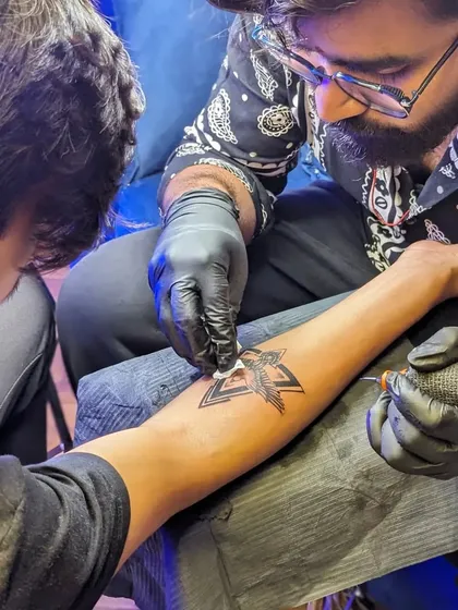 The tattooing process in action. You can see me carefully wiping the area to ensure clean lines and proper ink saturation, following strict hygiene protocols throughout.