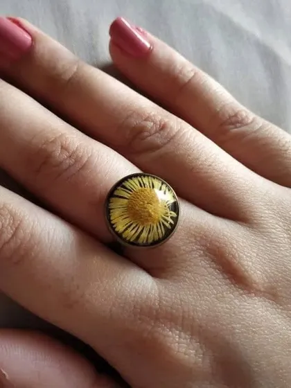 This ethnic ring features a preserved yellow flower, creating a bright and sunny look. The simple round setting is timeless and versatile.
