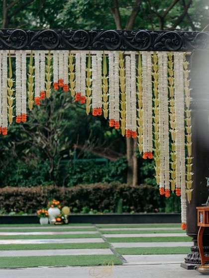 A wider view of the entrance arch, showing how the hanging floral strands create a curtain-like effect, making for a grand and picturesque entryway.