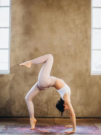 A visual of a one-legged wheel pose, demonstrating advanced flexibility and strength. Yoga is a powerful tool for boosting heart health by lowering blood pressure and reducing stress.